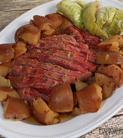 slow cooker corned beef and cabbage recipe with red potatoes on a platter