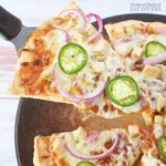 A slice of barbecue chicken pizza, ready to eat.