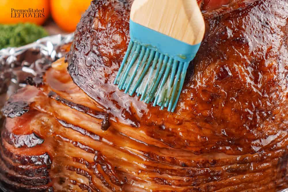 basting the ham with the honey glaze